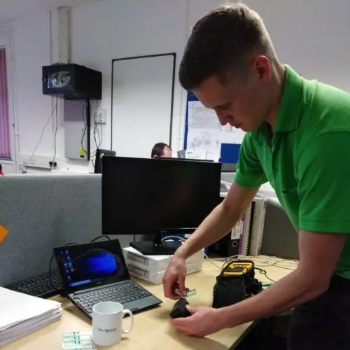 Staff member wearing a green polo completing a Pat Test