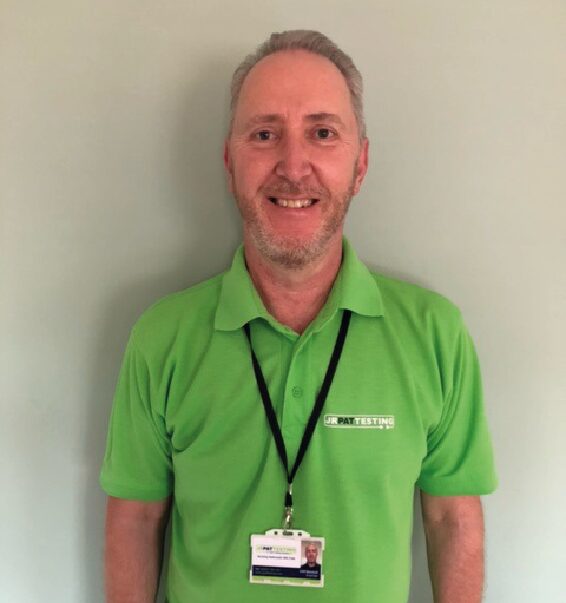 Staff member smiling wearing a green polo